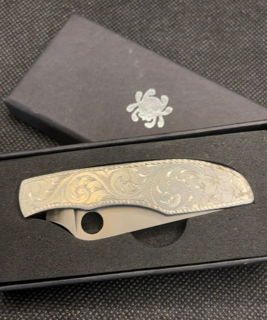 Double-sided, Sterling silver overlayed and hand engraved, Spyderco knife.  Overall length: 5.06”. Scales are 2.79”.    CUSTOM ORDER