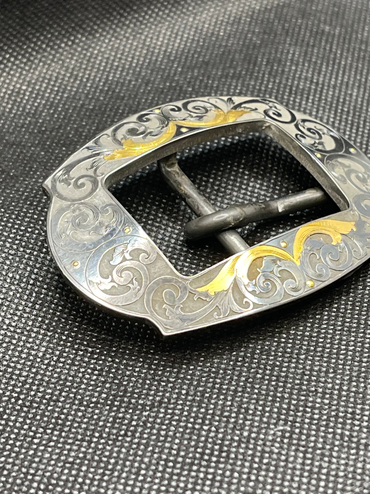 Hand engraved steel buckle, blued finish with and 24K gold inlay.  Fits 1” Belt