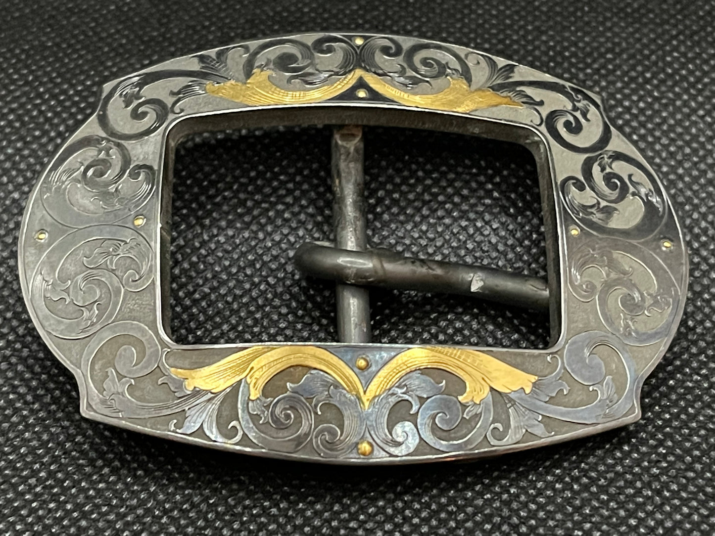 Hand engraved steel buckle, blued finish with and 24K gold inlay.  Fits 1” Belt